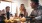 a group of people sitting at a table with food and drinks