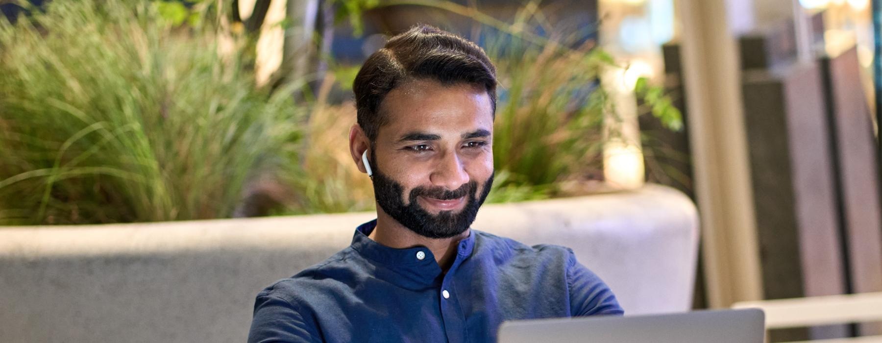 a man sitting on a bench with a laptop