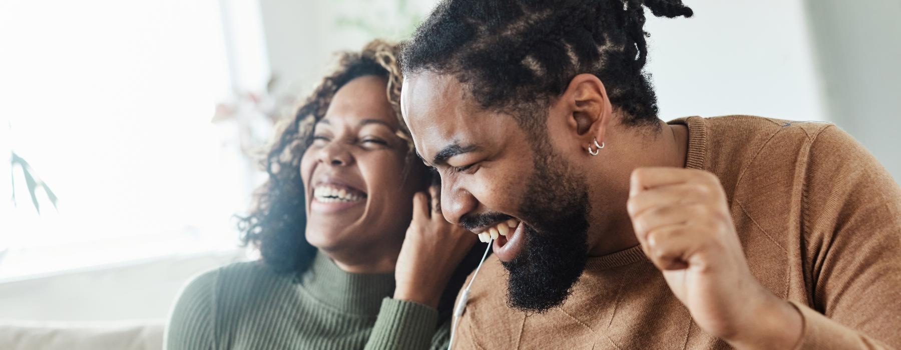 a man and woman laughing in a bright room