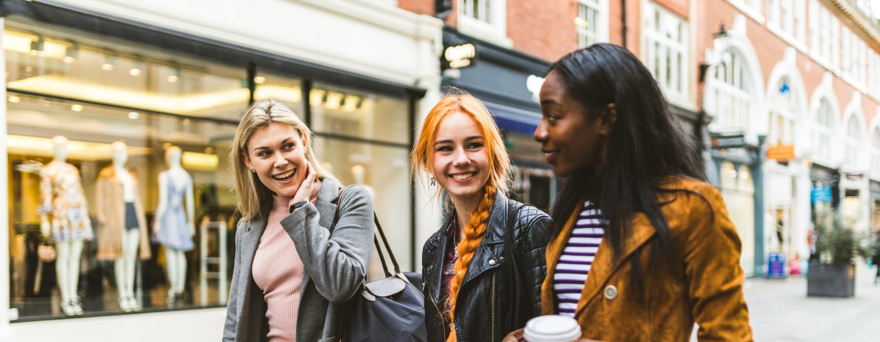 a group of women smiling as they window shop